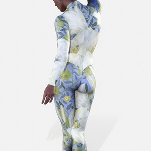 May include: A full-length, blue jumpsuit with a white floral print. The jumpsuit has long sleeves and a high neck.