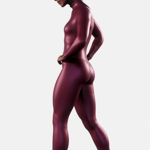 May include: A burgundy-colored, full-body jumpsuit with a high neckline and long sleeves. The form-fitting garment has a smooth, shiny texture and is worn without shoes. The model is walking on a white surface.