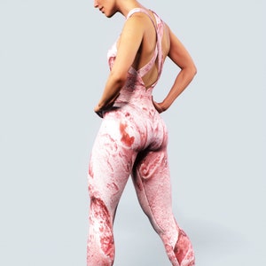 May include: A pink and white marble-patterned jumpsuit. The garment features a crisscross back and a close fit. The material looks stretchy, suitable for exercise or everyday wear. The measurements are in centimeters.