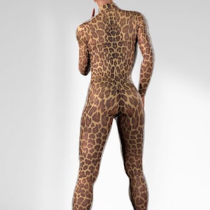 Puede incluir: Mono de cuerpo entero con estampado de leopardo marrón y beige. La prenda tiene mangas largas y cuello alto. Vista trasera del modelo, mostrando el diseño ajustado del mono.