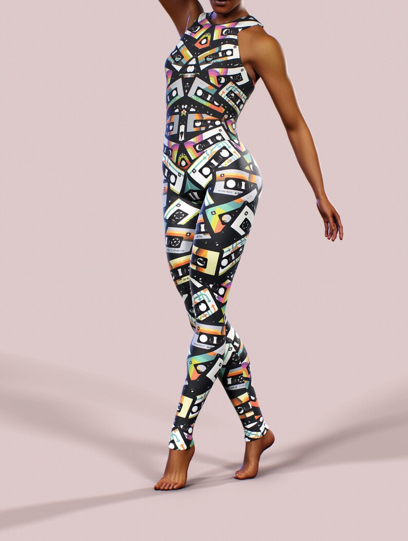 May include: A black jumpsuit with a colourful cassette tape print. The jumpsuit has a sleeveless design and a high neckline.