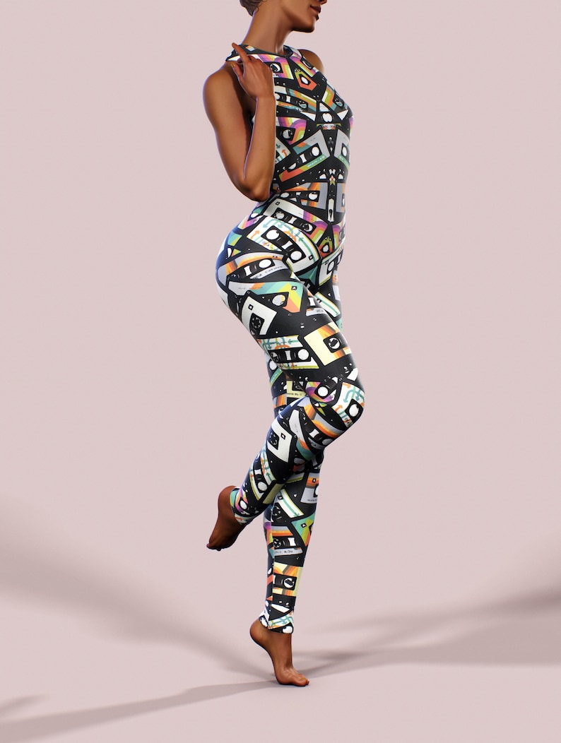 May include: A black jumpsuit with a colourful retro cassette tape pattern. The jumpsuit has a sleeveless design and a high neckline.