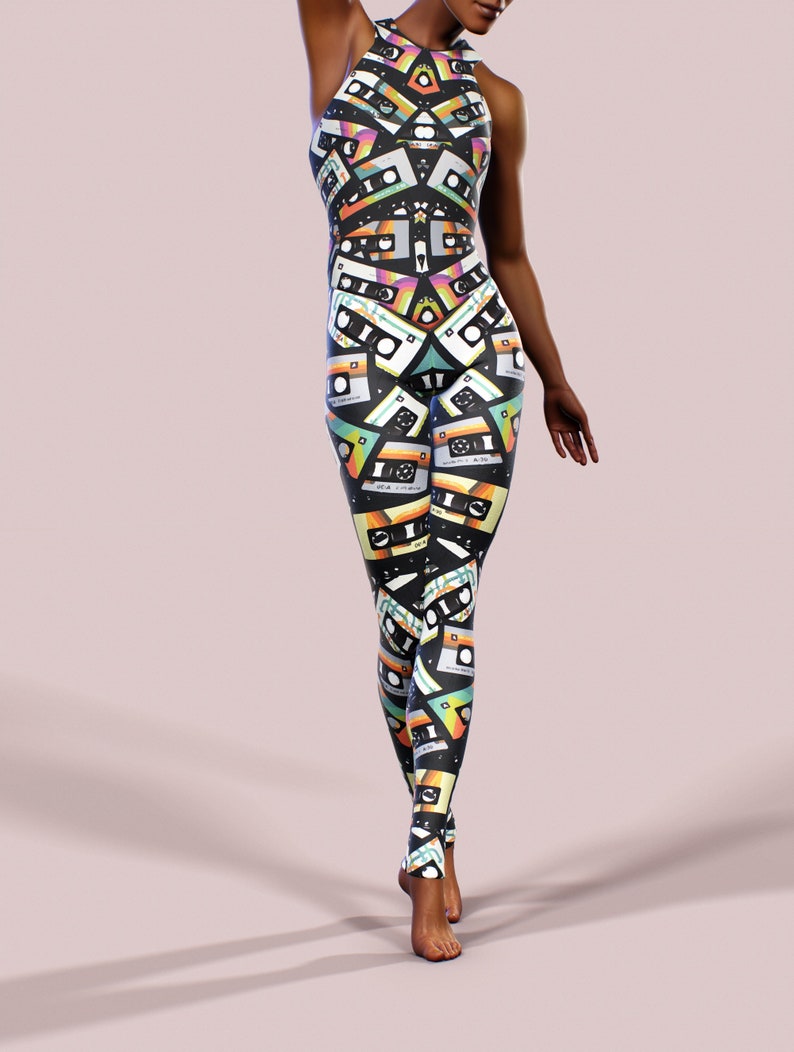 May include: A black jumpsuit with a colourful pattern of cassette tapes. The jumpsuit has a high neckline and a sleeveless design.