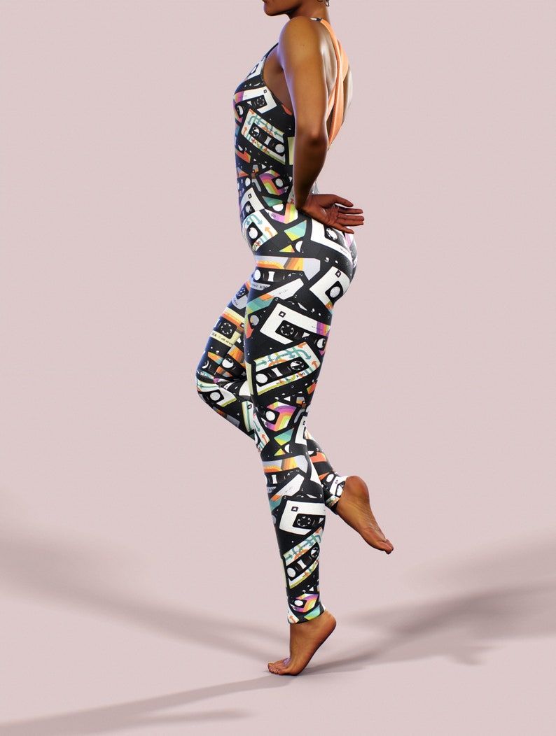 May include: Black leggings with a colourful pattern of cassette tapes. The leggings are form-fitting and have a high waist.