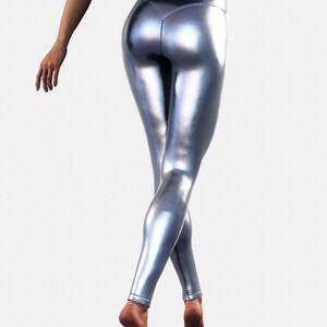 May include: High-waisted leggings in a metallic silver finish with a smooth, reflective surface. The leggings feature a fitted silhouette that extends to the ankles, showcasing a sleek, shiny texture that catches the light across the fabric.