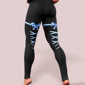 Pu&ograve; includere: Leggings neri con nastri e fiocchi azzurri. I leggings presentano un design a corsetto sul retro delle gambe, con lacci in nastro azzurro. I leggings sono aderenti e realizzati in materiale elasticizzato.