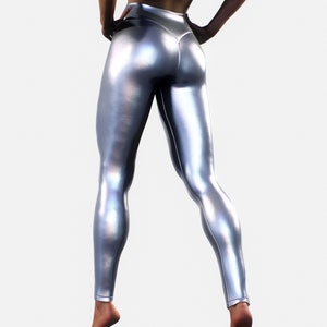May include: High-waisted leggings in a metallic silver finish with a smooth, reflective surface. The leggings feature a fitted silhouette that extends to the ankles, showcasing a sleek, form-fitting design with visible seams along the back.