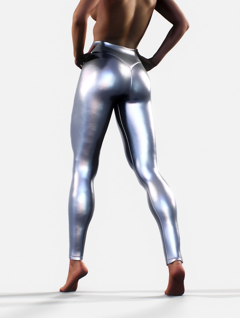 May include: High-waisted leggings in a metallic silver finish with a smooth, reflective surface. The leggings feature a fitted silhouette that extends to the ankles, showcasing a sleek, form-fitting design with visible seams along the back.
