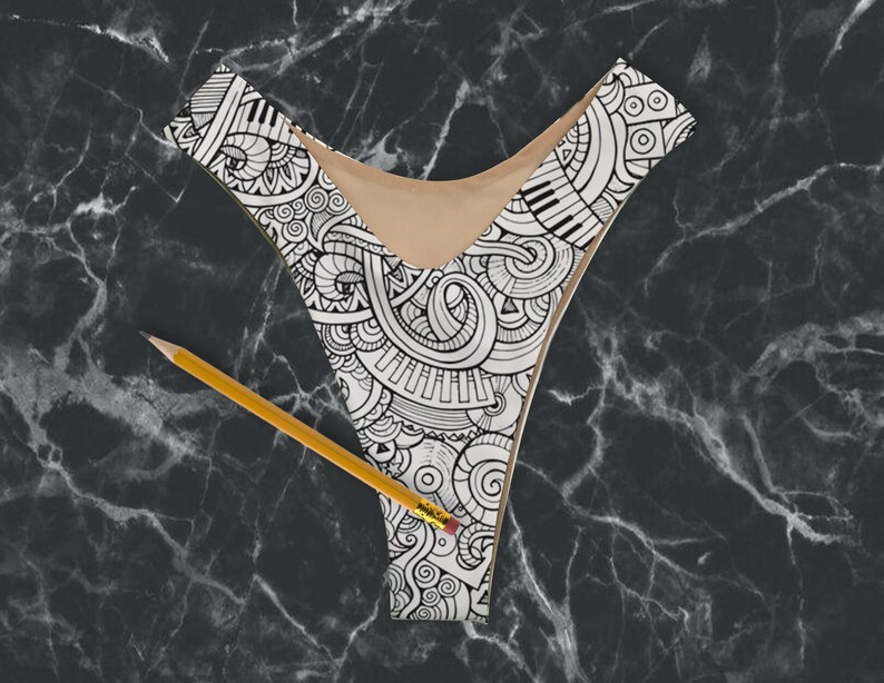 May include: Black and white patterned bikini top with a detailed design of musical notes, swirls, and other abstract shapes.