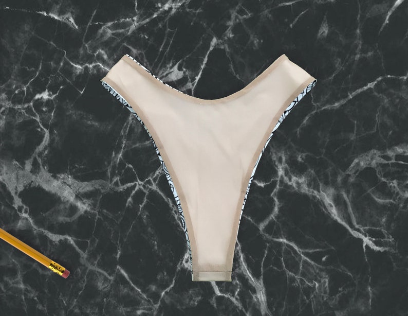 May include: Black and white patterned bikini bottom with a nude lining. The bikini bottom is made of a soft, stretchy fabric.