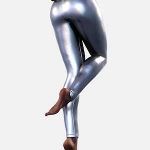 May include: High-waisted leggings in a metallic silver finish with a smooth, reflective surface. The leggings feature a fitted silhouette that extends to the ankles, showcasing a sleek, shiny texture that catches the light across the fabric.