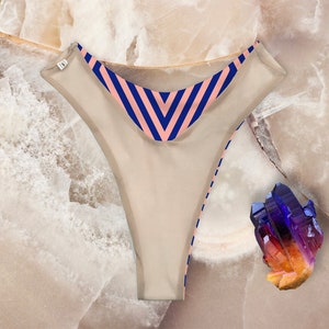 May include: Beige underwear with a pink and blue striped waistband.