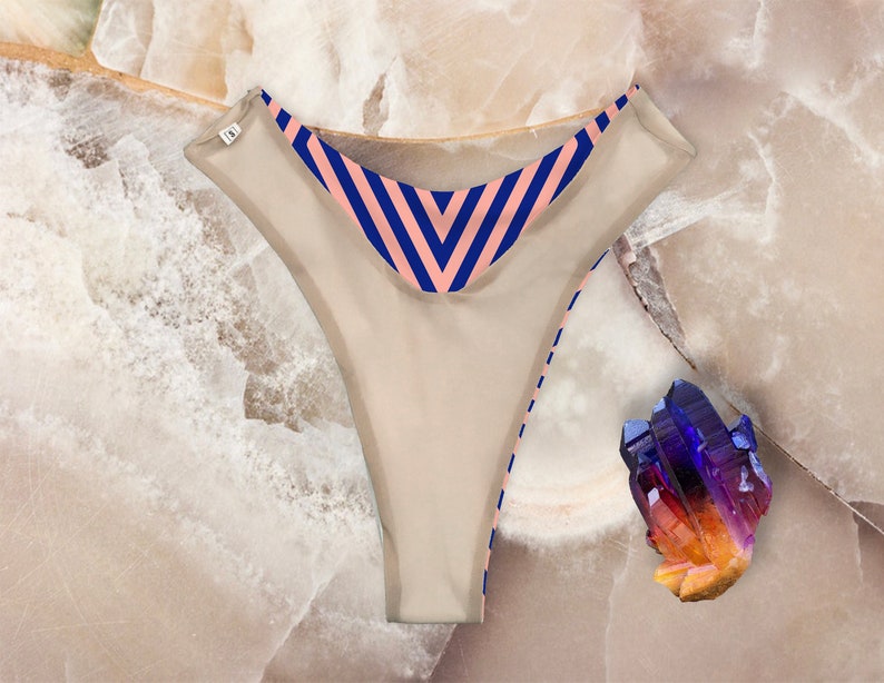 May include: Beige underwear with a pink and blue striped waistband.
