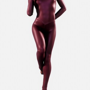May include: A burgundy-colored, full-body catsuit with long sleeves and a high neckline. The form-fitting garment has a V-shaped waistline and covers the legs. The person is barefoot and standing on one leg.