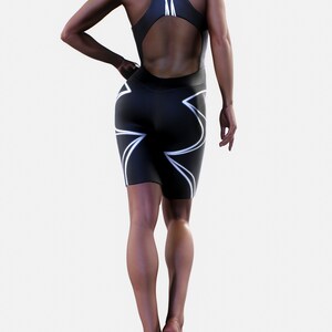 May include: Black one-piece athletic suit with white geometric design. The suit has a high neckline and a cutout back.