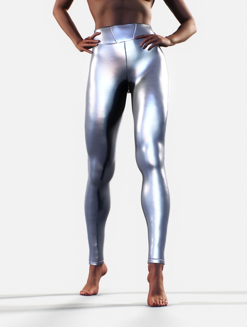 May include: High-waisted leggings in a metallic silver finish with a smooth, reflective surface. These form-fitting leggings feature a wide waistband and a sleek, seamless appearance that extends down to the ankles, showcasing a bright, polished look.