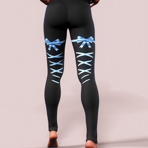 Pu&ograve; includere: Leggings neri con fiocchi di nastro azzurro chiaro e design a stringhe bianche incrociate sulla parte inferiore delle gambe. I leggings sono a vita alta e aderenti. La modella &egrave; in piedi con le mani sui fianchi.