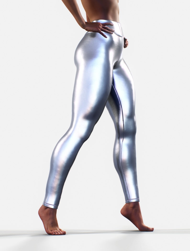 May include: High-waisted leggings with a metallic silver finish and a smooth, reflective surface. The leggings feature a form-fitting design that extends to the ankles, showcasing a sleek, uniform appearance with visible vertical seam detailing.