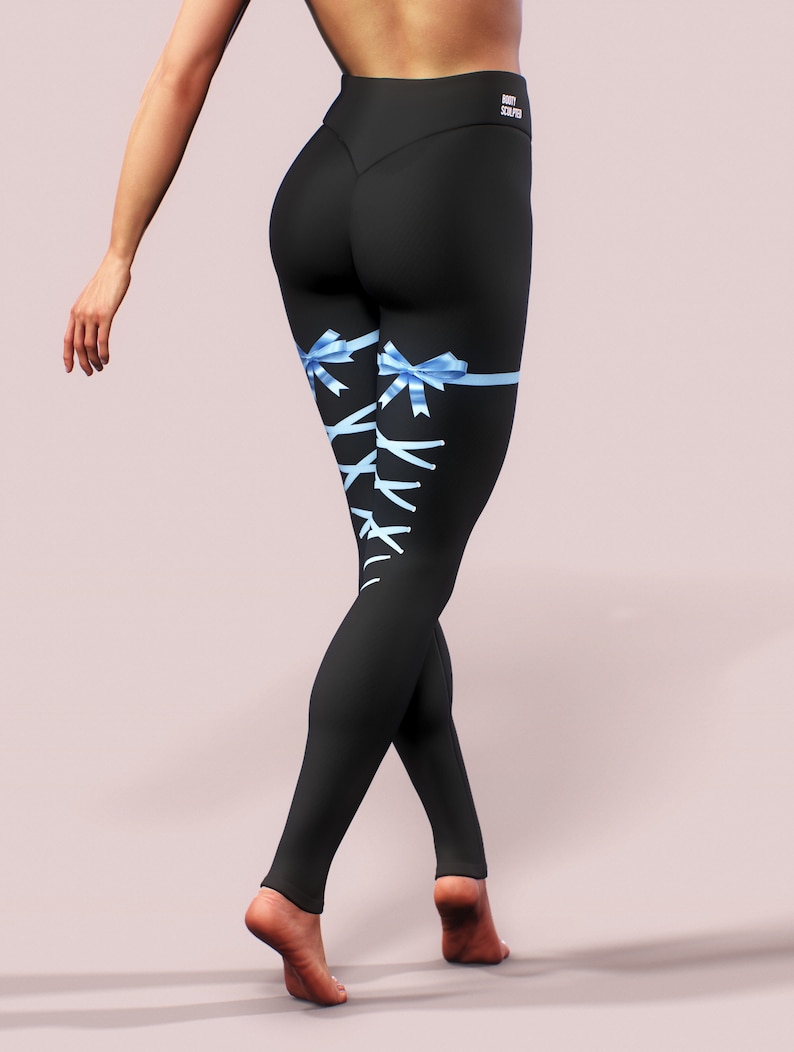Pu&ograve; includere: Leggings neri con nastri e lacci blu chiaro sulle gambe. I leggings a vita alta hanno la scritta "BOOTY SCULPT" stampata sul retro della cintura. I leggings sono aderenti.