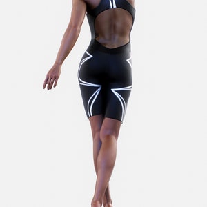 May include: A black one-piece athletic suit with white geometric designs. The suit has a high neckline and a cutout back.
