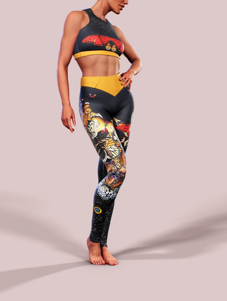 May include: A black and yellow sports bra and leggings set with a butterfly print. The leggings have a yellow waistband and a butterfly print all over.