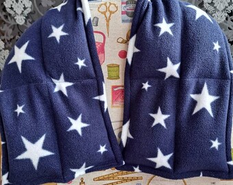 May include: A navy blue fleece wrap with a white star design. The wrap is displayed on a mannequin. The background features a floral pattern and a sewing-themed fabric.