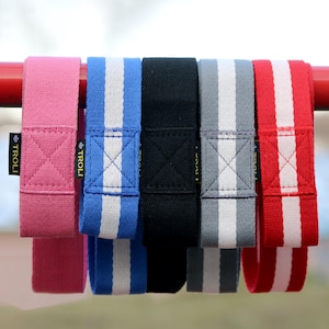 Può includere: Cinque bande di resistenza in tessuto con strisce bianche. Le bande sono rosa, blu, nero, grigio e rosso. Le bande sono etichettate "TROLLI" in giallo.