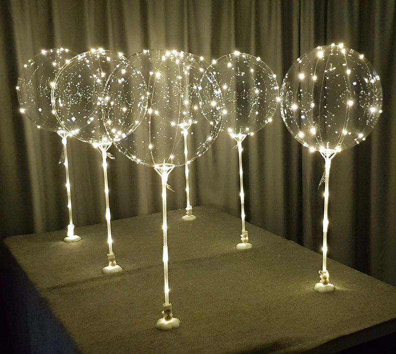 6 LED light up  balloon on a table with stick and stand in warm white color