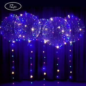 May include: Clear, round balloons with embedded multi-colored LED lights. The balloons are suspended, with strings of lights hanging down. The image includes the text "12pc" in a white oval.