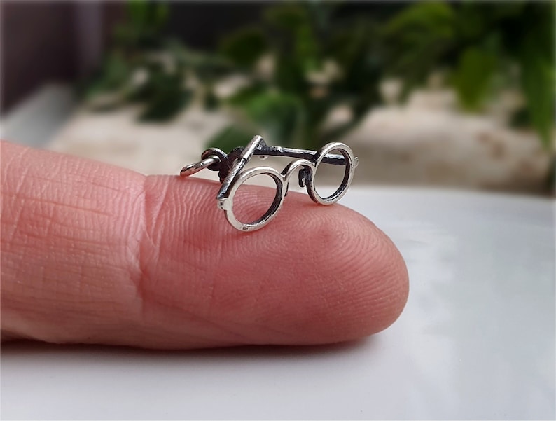May include: A silver charm in the shape of a pair of spectacles.