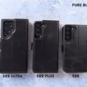 May include: Three black leather phone cases for the Samsung Galaxy S22 Ultra, S22 Plus, and S22. The cases are all closed and have a flap that covers the screen. The text "PURE BLACK" is at the top of the image. The text "S22 ULTRA", "S22 PLUS", and "S22" are at the bottom of the image.