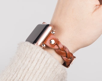 May include: A rose gold Apple Watch with a brown leather braided band. The band has decorative metal studs.