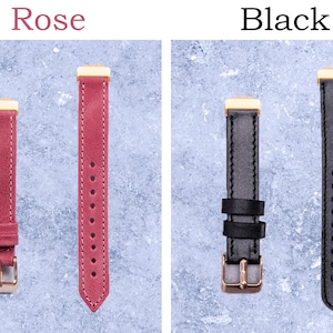 May include: Two watch straps, one rose-colored and one black, are displayed. The rose strap has a gold-colored buckle and hardware, with the word "Rose" above it. The black strap has a gold-colored buckle and hardware, with the word "Black" above it.