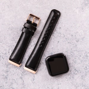May include: Two black leather watch bands with gold hardware. One band has a buckle closure and the other has a pin and loop closure.