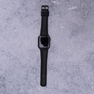 以下が含まれることがあります： 黒い革バンドの黒いApple Watchです