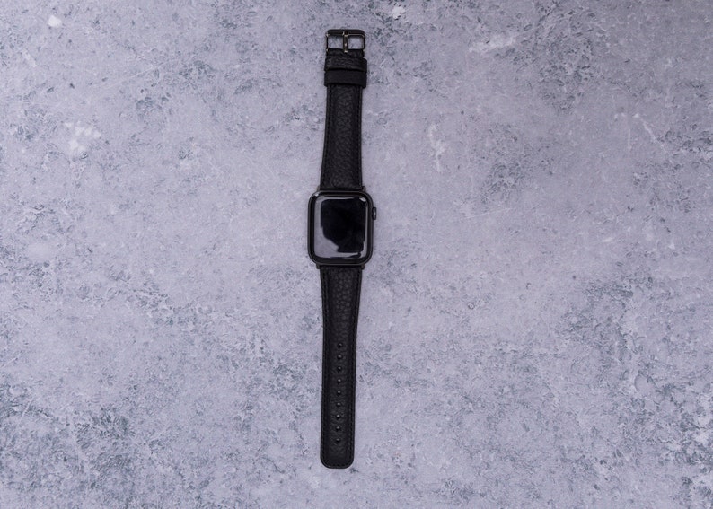 以下が含まれることがあります： 黒い革バンドの黒いApple Watchです