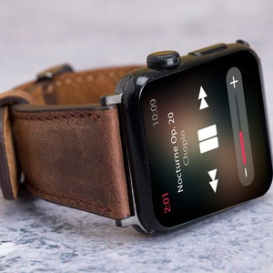 May include: A black smartwatch with a brown leather strap playing music. The screen shows "Nocturne Op. 20 Chopin" and the time 10:09. The music player controls are visible on the screen.