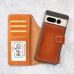 Pode incluir: Uma capa de telefone de couro marrom com uma carteira embutida. A capa tem slots para cartões de crédito e uma aba que cobre o telefone. A capa também tem uma pequena janela que diz "Proteção RFID".