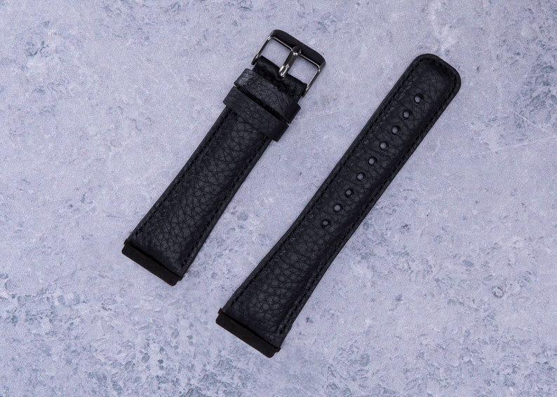 May include: Two black leather watch straps with silver buckles. One strap has a smooth finish and the other has a textured finish.