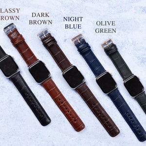 K&ouml;nnte beinhalten: Sechs verschiedene farbige Lederarmb&auml;nder f&uuml;r eine Apple Watch. Die Armb&auml;nder sind in den Farben: Schwarz, Braun, Dunkelbraun, Nachtblau, Olivgr&uuml;n.