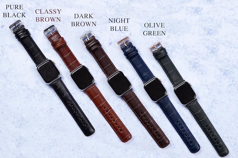 K&ouml;nnte beinhalten: Sechs verschiedene farbige Lederarmb&auml;nder f&uuml;r eine Apple Watch. Die Armb&auml;nder sind in den Farben: Schwarz, Braun, Dunkelbraun, Nachtblau, Olivgr&uuml;n.