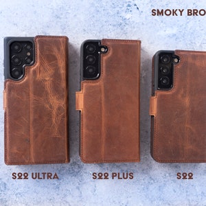 May include: Three leather phone cases in the colour "Smoky Brown" for the Samsung Galaxy S22 Ultra, S22 Plus, and S22. The cases are all closed and have a flap that covers the screen.