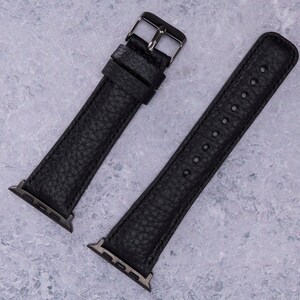 以下が含まれることがあります： 銀色の金具が付いた黒い革製の腕時計バンド2本。バンドはApple Watch用に設計されています。