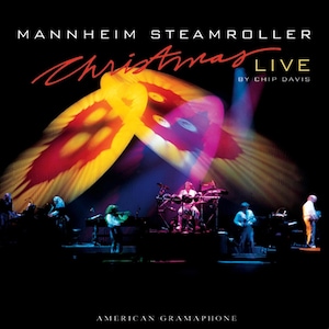 May include: A concert poster for Mannheim Steamroller's Christmas Live album. The poster features a colorful, abstract design with the band's name and album title in large, bold letters. The text "By Chip Davis" appears below the album title.