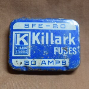 May include: A rectangular blue metal Killark Fuses tin with white lettering. The tin reads "SFE-20" at the top, "Killark FUSES" in the center, and "20 AMPS" at the bottom. The Killark logo is in the lower left corner.