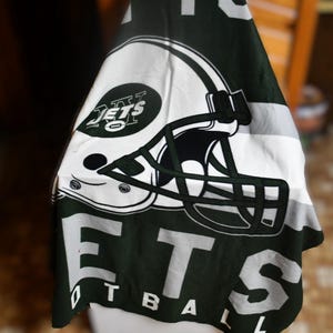 Puede incluir: Toalla de los New York Jets de color verde y blanco con un casco de fútbol y las palabras "New York Jets Football" impresas en ella.