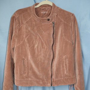 May include: A dusty rose velvet moto jacket with a zipper closure and a drawstring at the bottom.