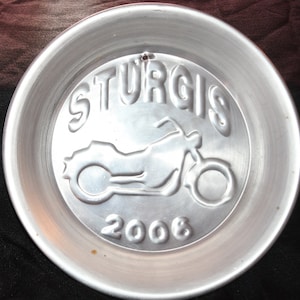May include: A silver metal plate with the words "Sturgis 2006" and a motorcycle silhouette.
