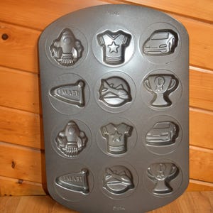 Wilton Ultra Bake 12 Cavity Sports/Team/Boy Theme Cookie Pan-Rocket/Trophy/Jet/Car - Measures 16.5" X 11" - Excellent Used Condition