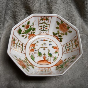 May include: Octagonal white ceramic bowl with a gold rim and intricate floral and bird designs in shades of green, orange, and blue.